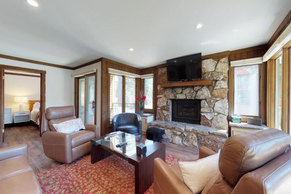 un soggiorno con divano e camino in pietra di Mountainback 90 a Mammoth Lakes
