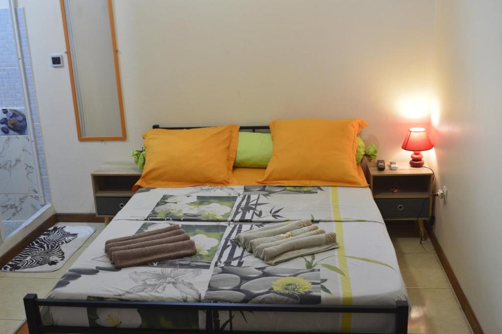 フォール・ド・フランスにあるRésidence Plocusのベッドルーム1室(オレンジ色の枕付きのベッド1台付)