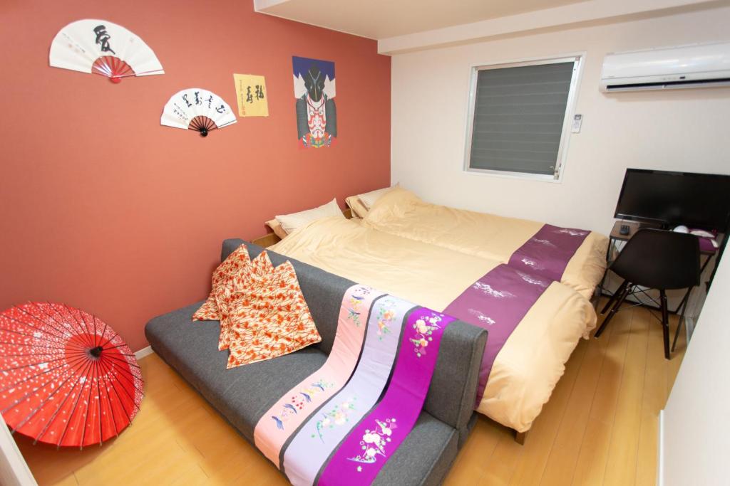 a bedroom with a bed and a couch with an umbrella at Miyabiro 105 in Kyoto