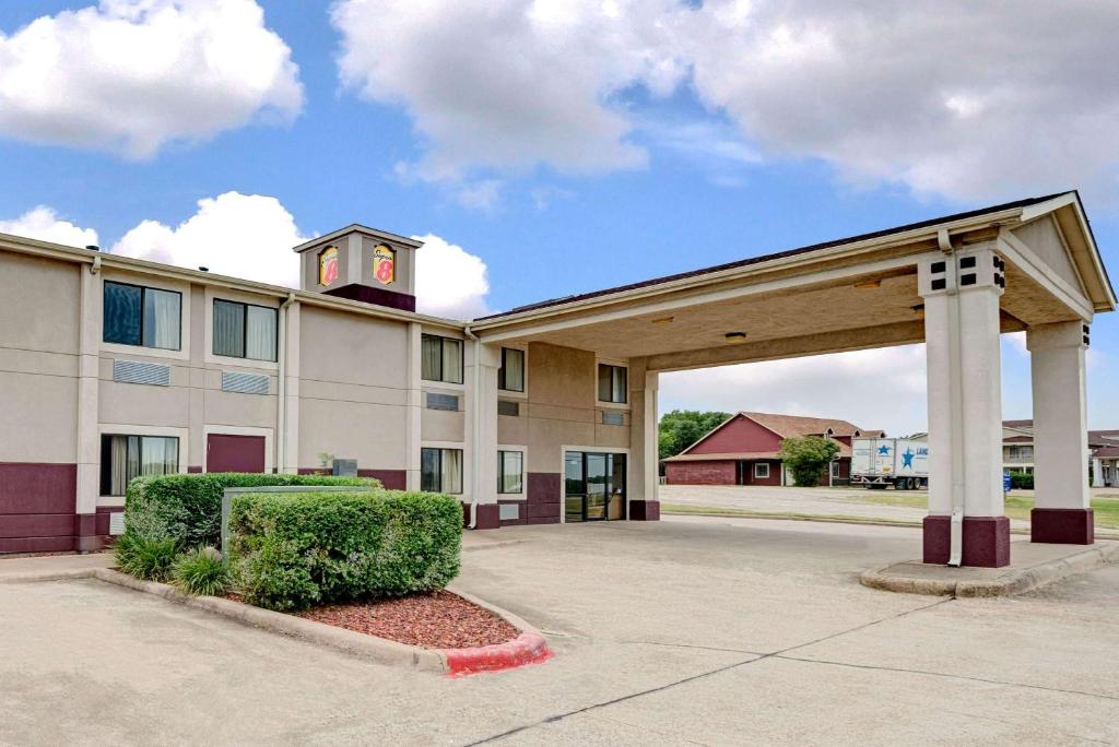 a building with a clock tower on top of it at Super 8 by Wyndham Waxahachie TX in Waxahachie