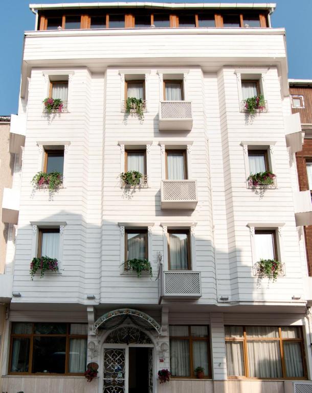 un edificio blanco con plantas en macetas encima en Mevlana Hotel, en Estambul