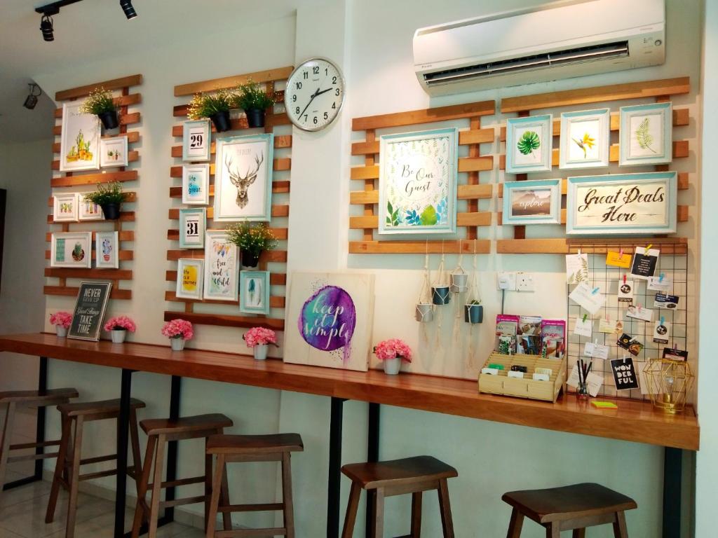 un bar con taburetes y un reloj en la pared en Maple Inn, en Kuala Lumpur