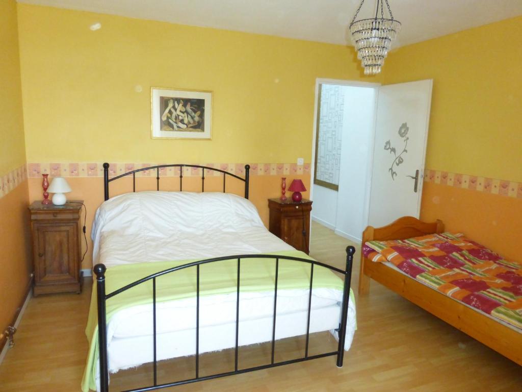a bedroom with yellow walls and a bed and a window at Gîte de la Côte in Viéville