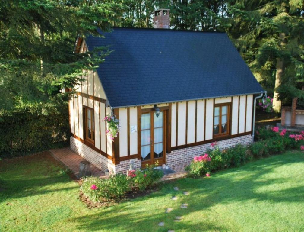 una pequeña casa con techo azul en Chambres d'hôtes La Petite Flambée, en Le Tronquay