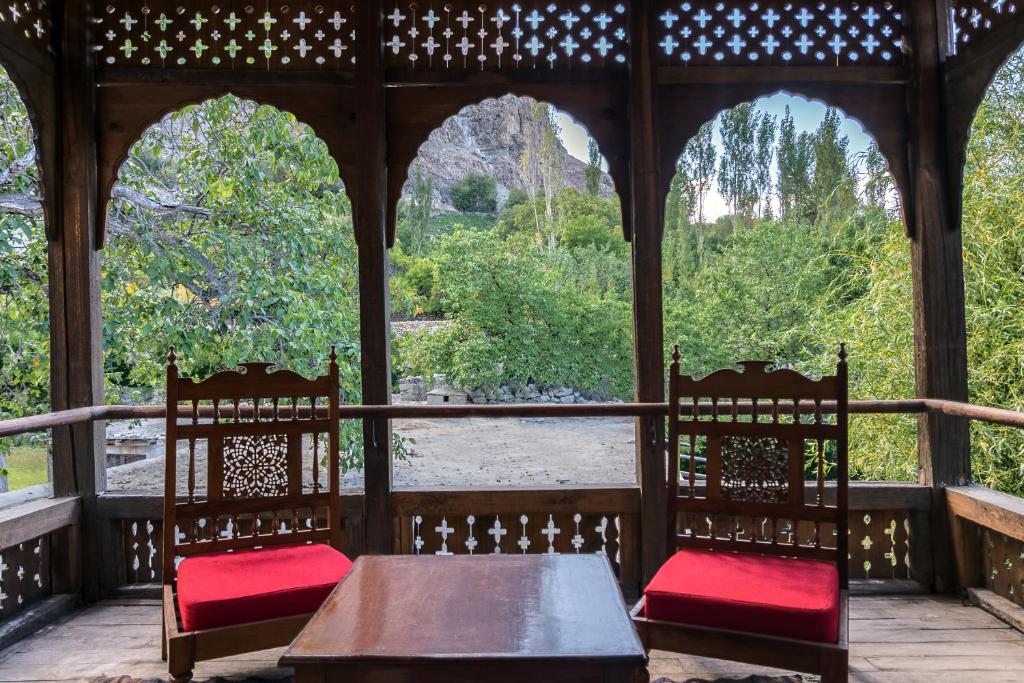 a gazebo with two chairs and a table with red seats at Serena Khaplu Palace in Khaplu