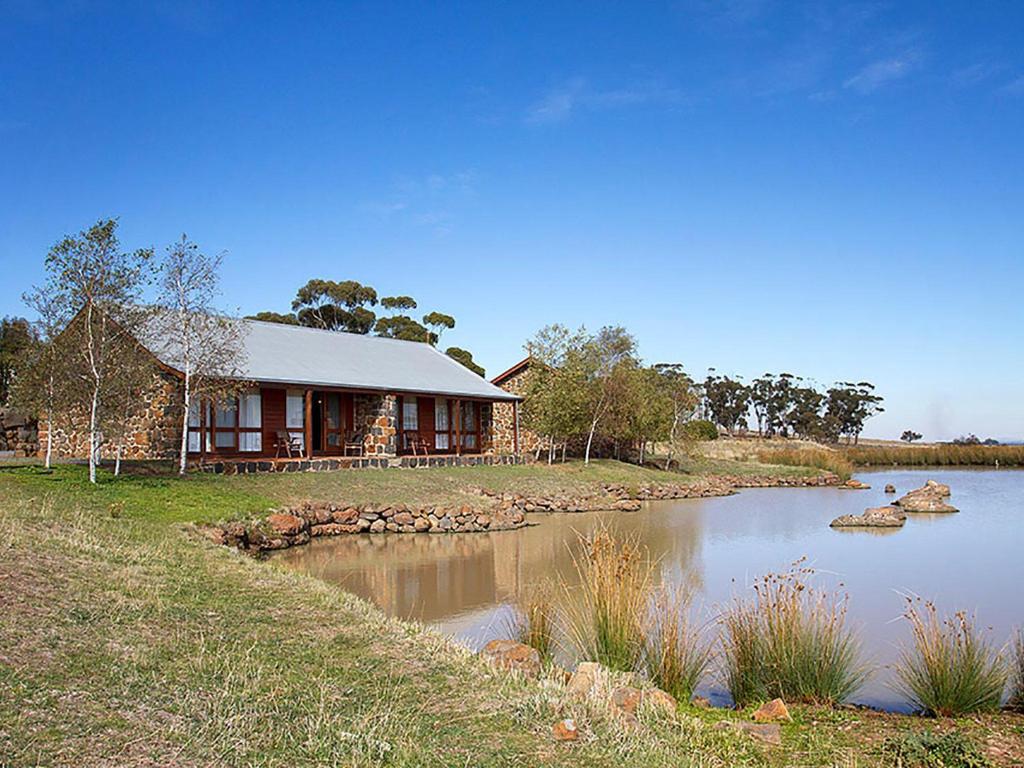 una casa junto a un río con un edificio en Tuki Retreat, en Smeaton