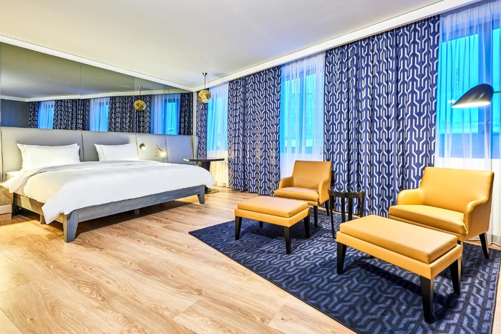 - une chambre avec un lit et deux chaises dans l'établissement Radisson Blu Hotel, Kyiv City Centre, à Kiev