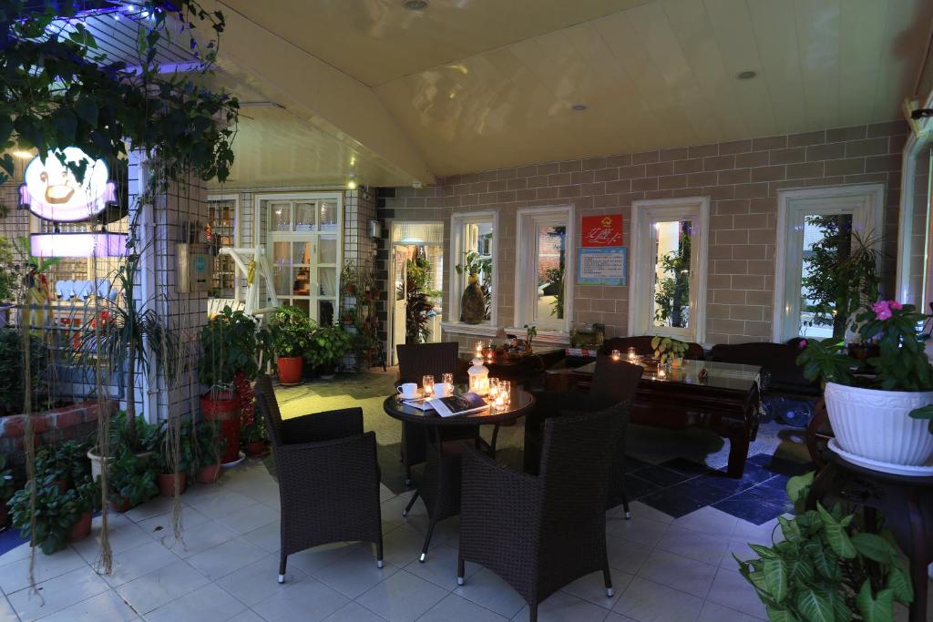 un ristorante con tavolo, sedie e piante di Avica Homestay a Wujie