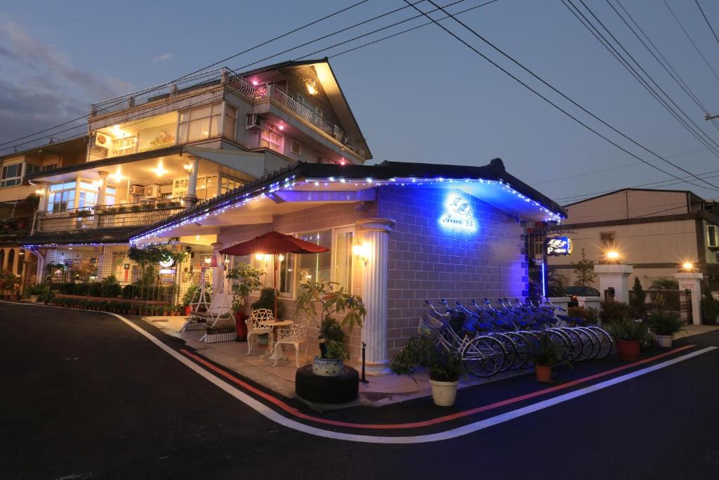 a house with blue lights on the front of it at Avica Homestay in Wujie