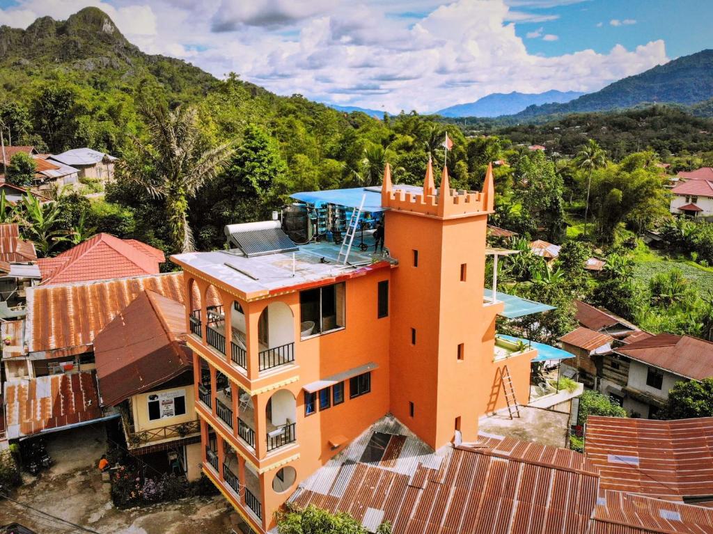 ein orangenes Haus mit einem Turm auf einer Stadt in der Unterkunft Sulawesi Castle in Rantepao