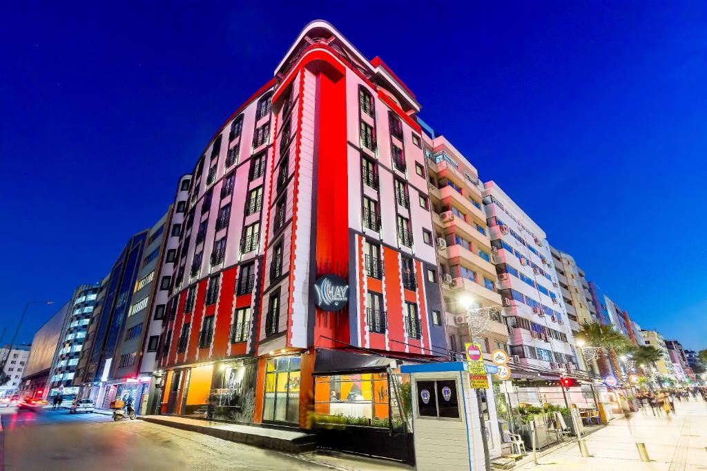 a red building on a city street at night at Hay Hotel Alsancak in Izmir