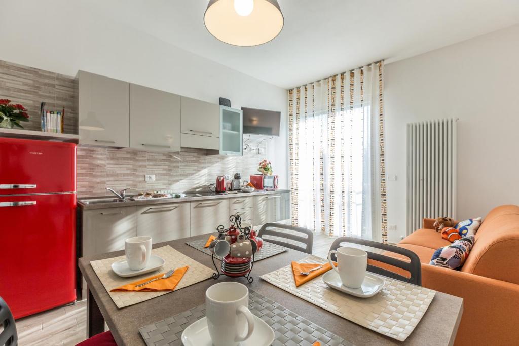 a kitchen and dining room with a table and a red refrigerator at Martina, Bologna by Short Holidays in Bologna