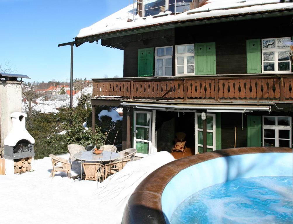 a house with a swimming pool in the snow at Schatzl Hütte in Bad Tölz