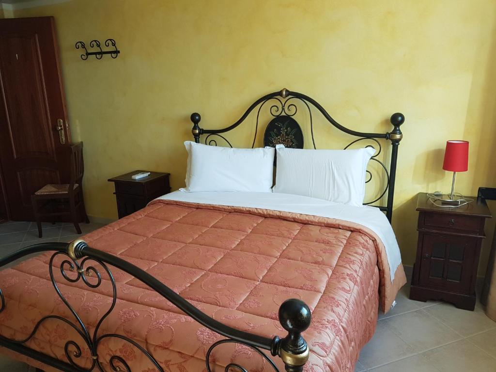 una camera da letto con un grande letto con cuscini bianchi di Le Tre Rose a Bono