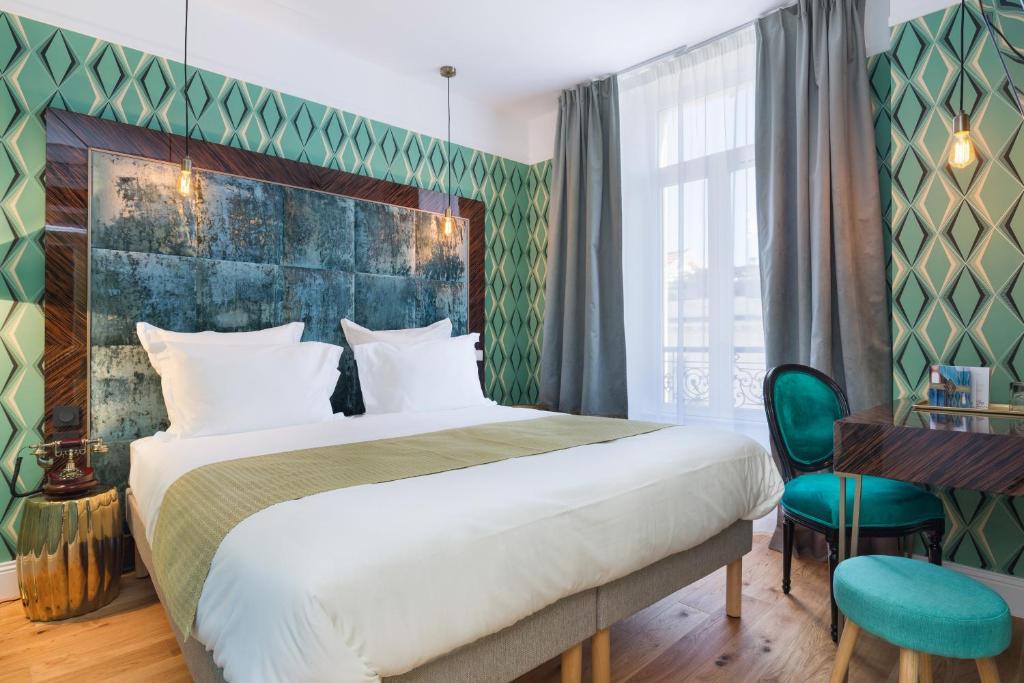 a bedroom with a large bed and a desk at The Jay Hotel by HappyCulture in Nice