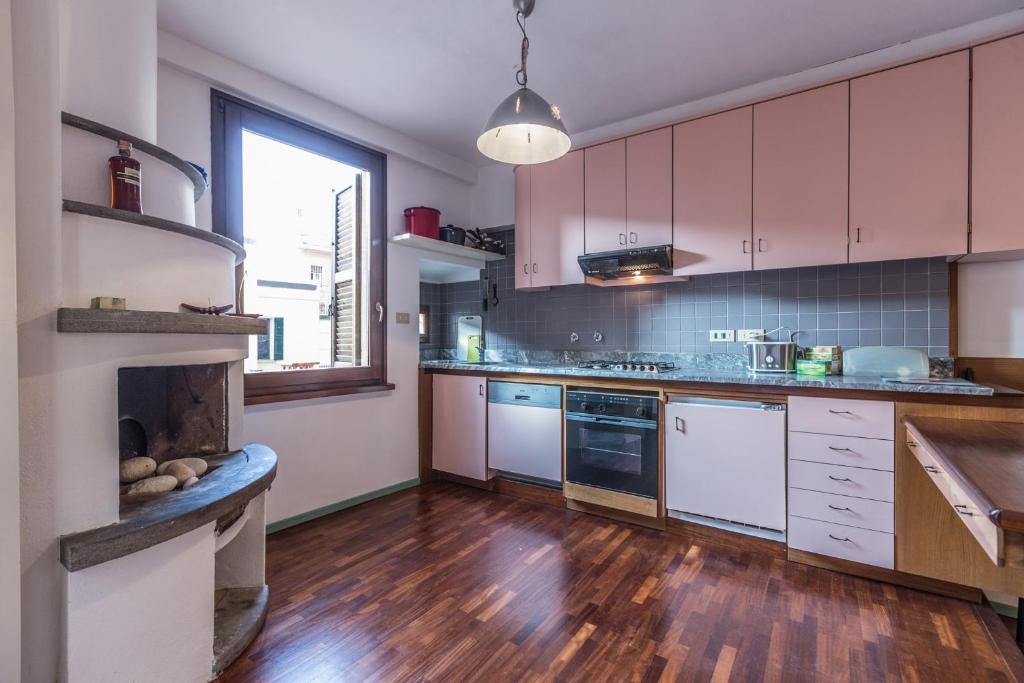 a kitchen with white cabinets and a wooden floor at Unione, Bologna by Short Holidays in Bologna