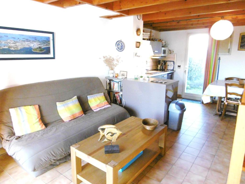 uma sala de estar com um sofá e uma mesa em Maisonnette Solenn em Sarzeau