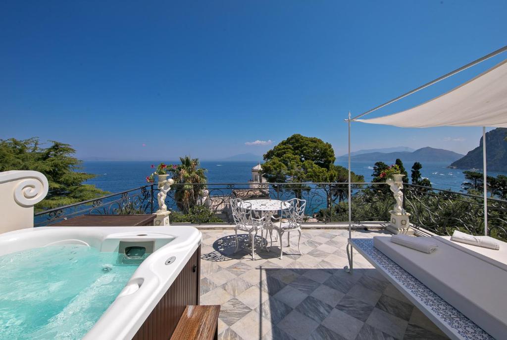 a hot tub on a patio with a view of the ocean at Luxury Villa Excelsior Parco in Capri