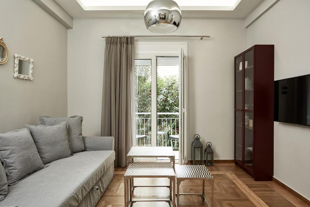 ein Wohnzimmer mit einem Sofa und einem Fenster in der Unterkunft Charming Studio Apartment in Athen