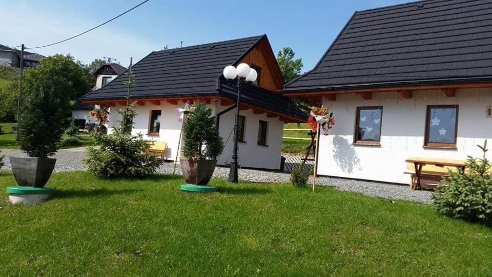 a white house with a picnic table in a yard at Domki Górskie Zacisze in Koniaków