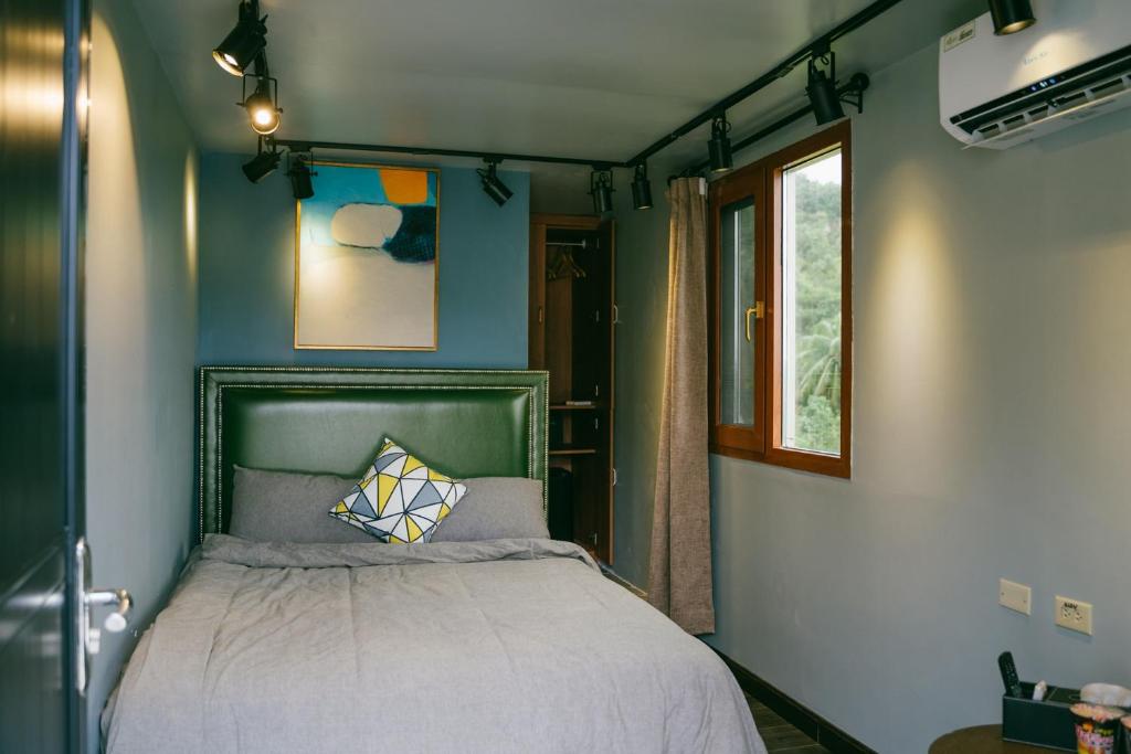 a bedroom with a bed and a window at Saipan Skyline Designers Hotel in Saipan