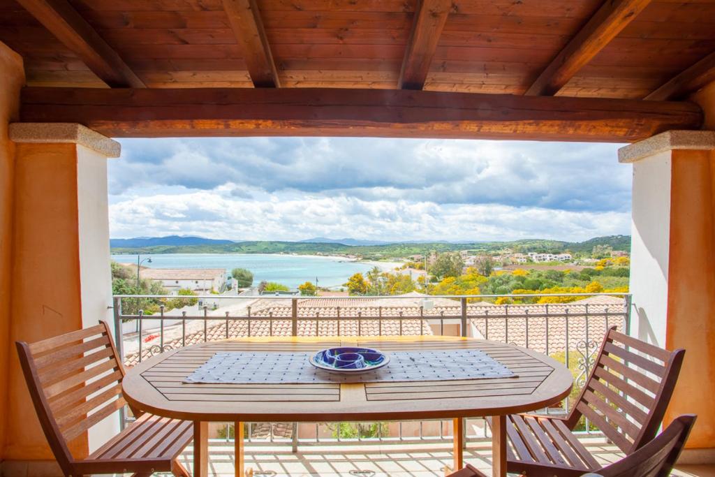 a table on a balcony with a view of the water at Maestrale Flat - Klodge in Olbia
