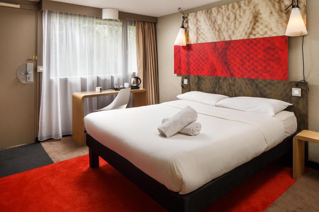 a hotel room with a large bed and a flag at ibis Birmingham Centre Irving Street in Birmingham