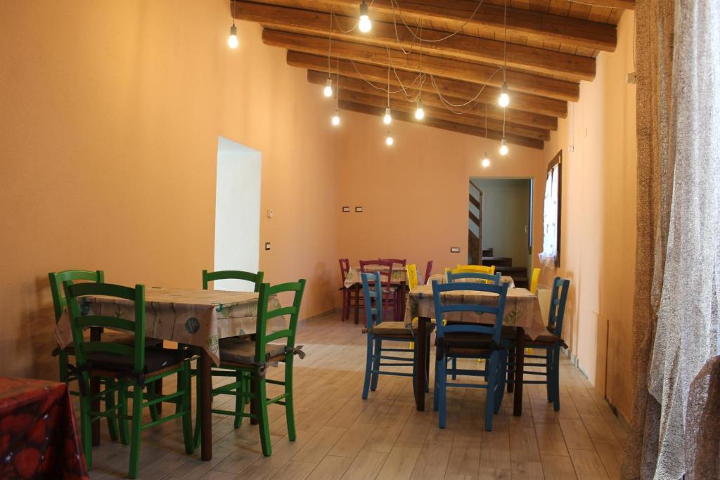 una sala da pranzo con tavoli, sedie e luci di Sa Domu Beccia B&B a Uras