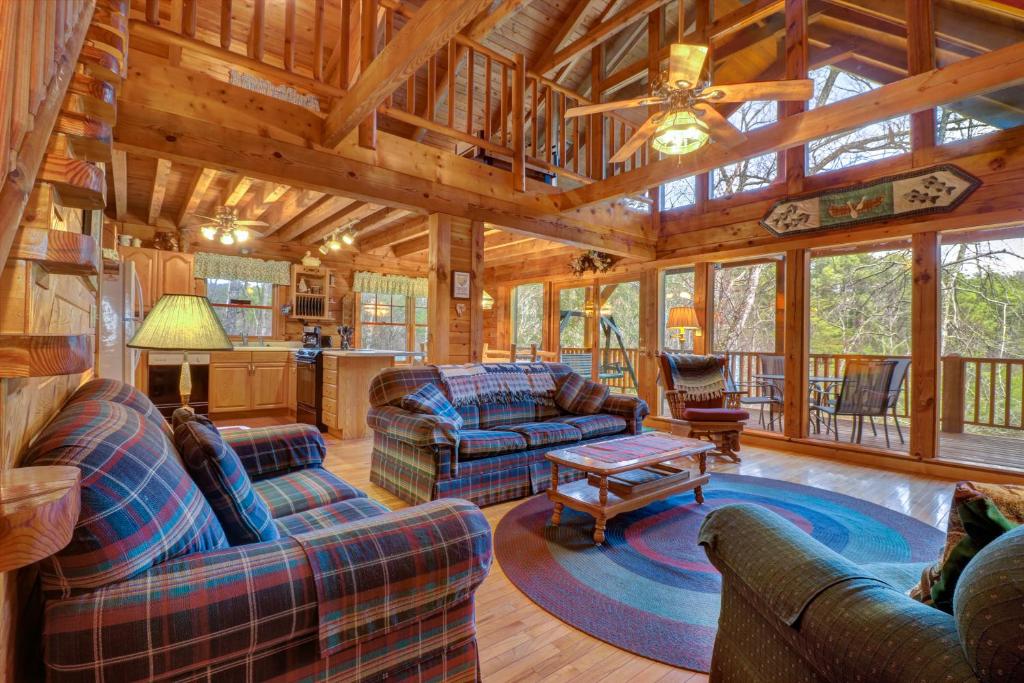 a living room with couches and a table in a cabin at Peak A View in Townsend