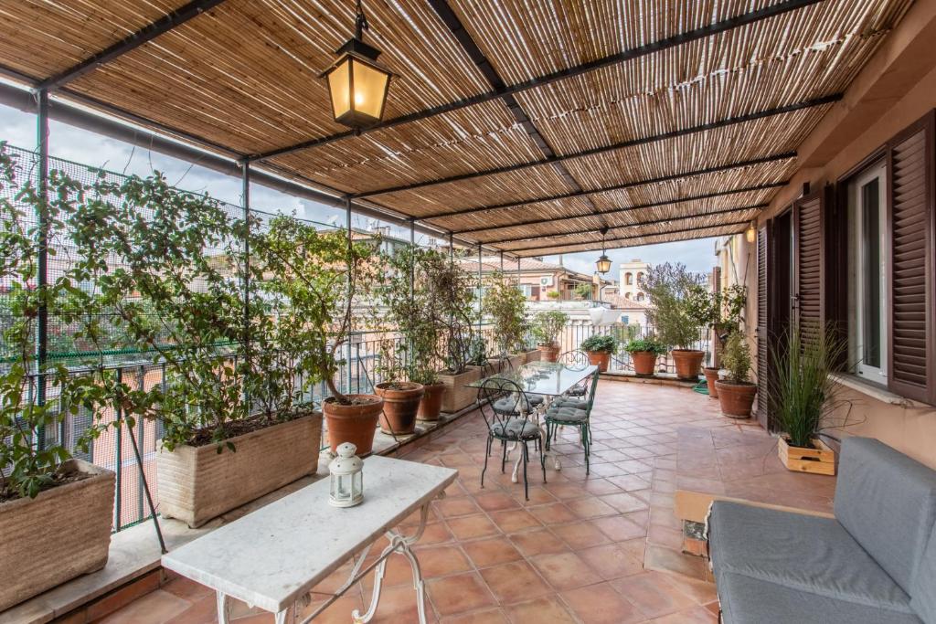 an outdoor patio with tables and potted plants at Gambero Apartments in Rome