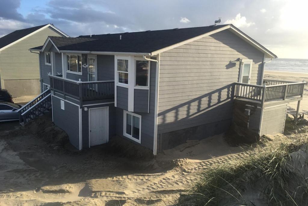 uma pequena casa na praia com uma varanda em Bayshore Modern Beach House em Waldport