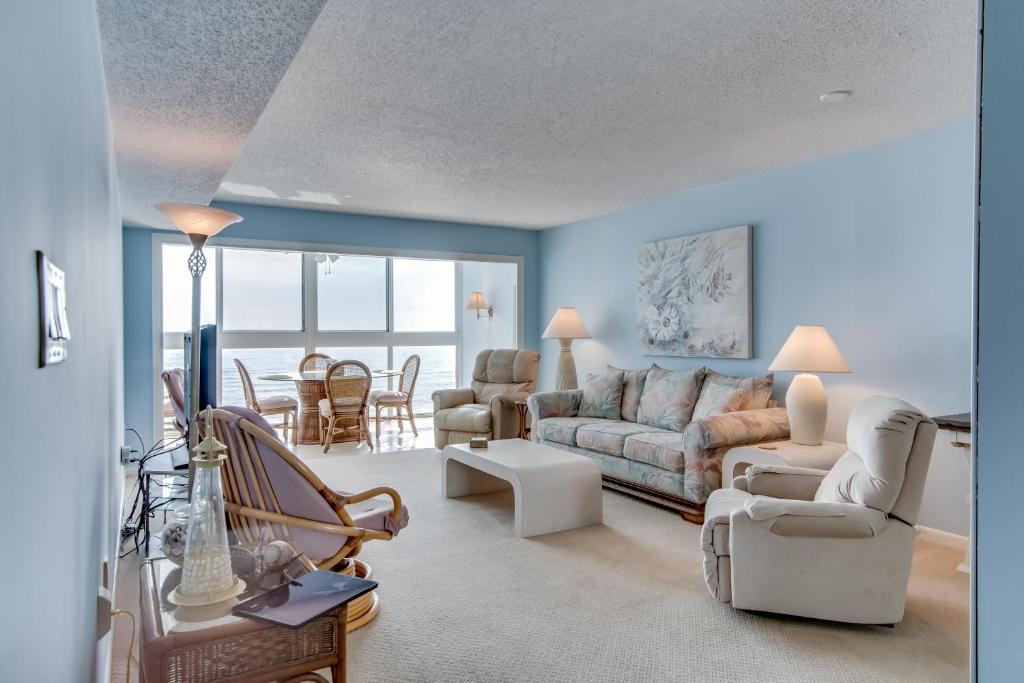 a living room with blue walls and a couch and chairs at Edgewater West #62 in Gulf Shores