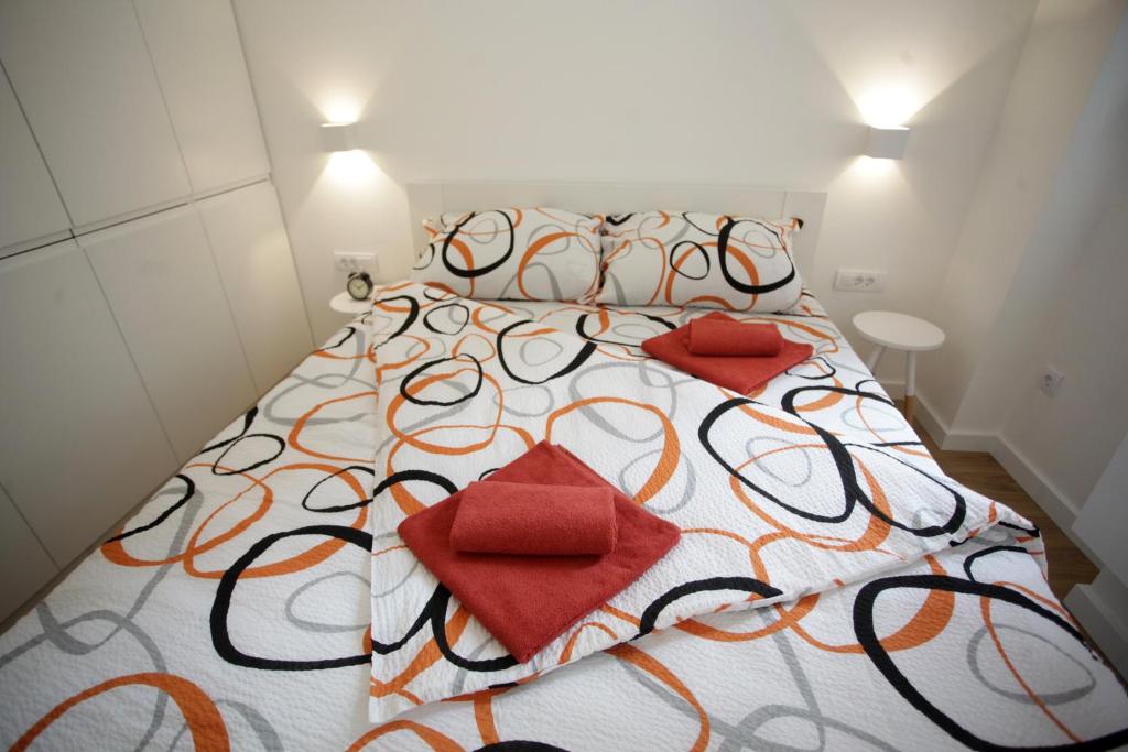 uma cama grande com duas almofadas vermelhas em City Center Belgrade Cozy Apartment Skadarlija em Belgrado