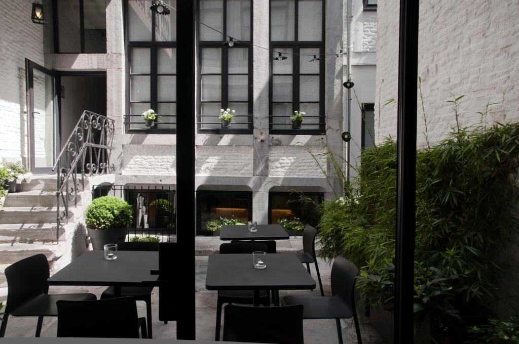 
a patio area with chairs, tables, and tables with umbrellas at Hotel Neuvice in Liège
