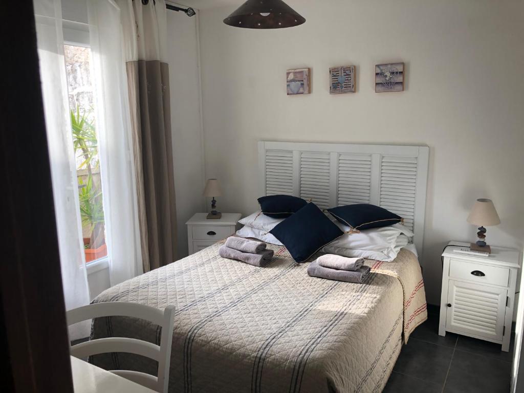 1 dormitorio con 1 cama con toallas en Hôtel Restaurant Le Provençal, en Le Grau-du-Roi