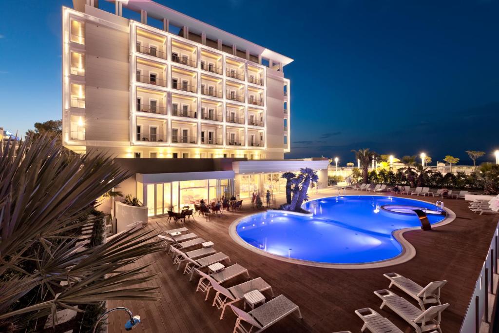 un hotel con piscina di fronte a un edificio di Hotel Ambasciatori a Riccione