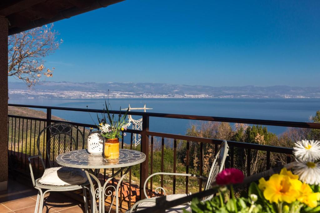 a table on a balcony with a view of the water at The Terrace in Mošćenice
