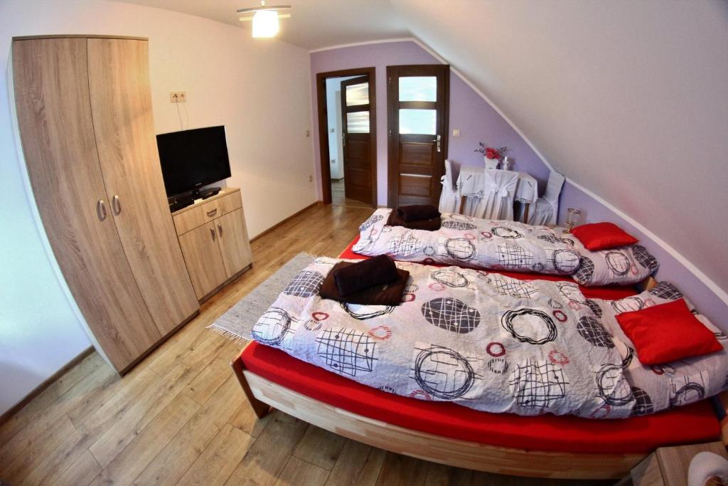 a bedroom with two beds and a flat screen tv at Domek Obidza 362 - Agroturystyka in Obidza