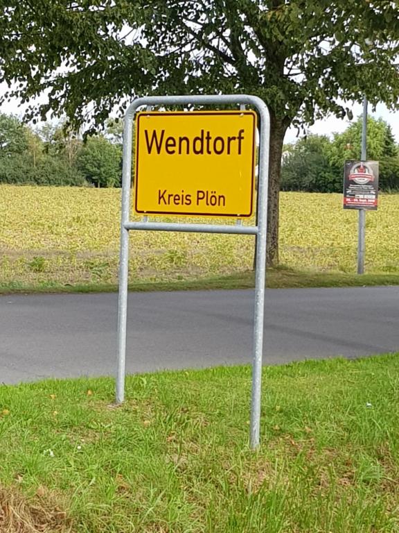 a yellow sign on the side of a road at Am Park 2 in Wendtorf