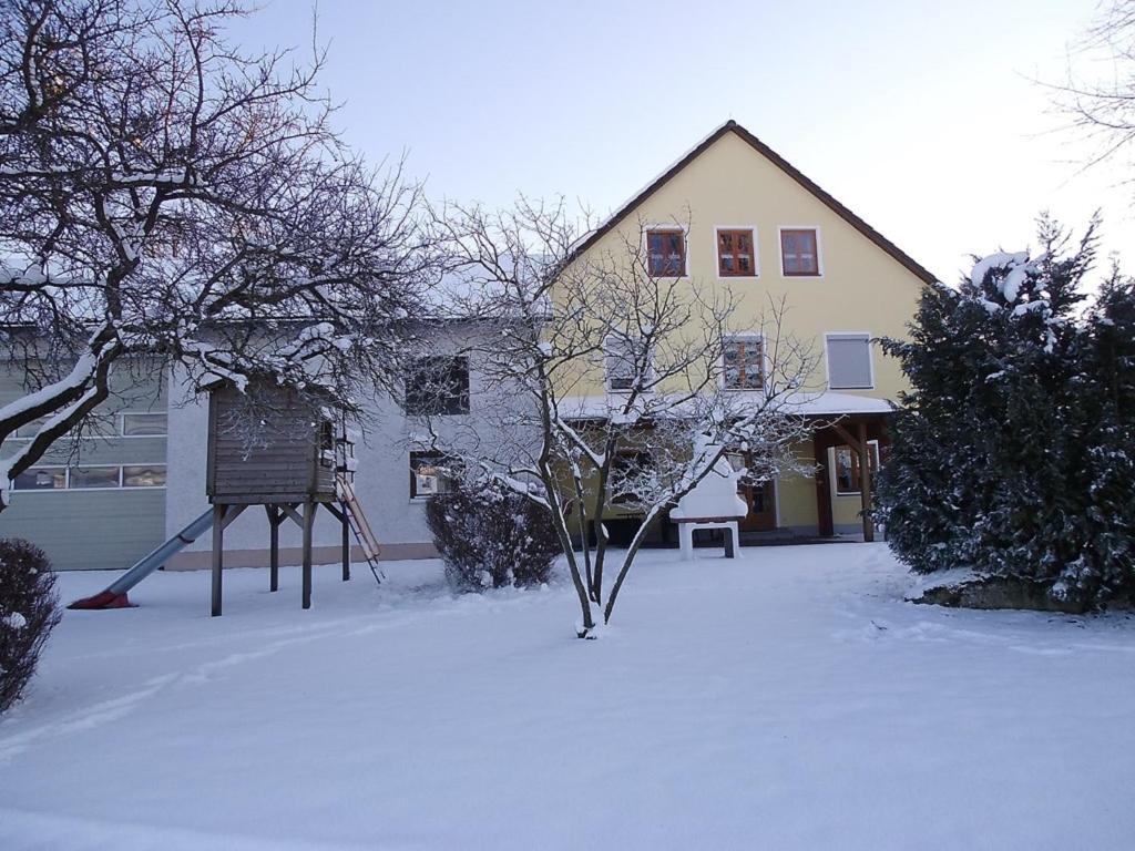 a building with a sign in the snow at Ferienwohnungen Peterbartl-Hof in Plößberg