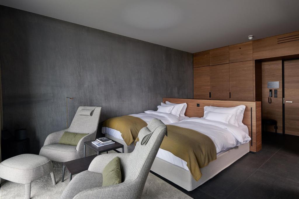 a bedroom with a large bed and two chairs at The Retreat at Blue Lagoon Iceland in Grindavík