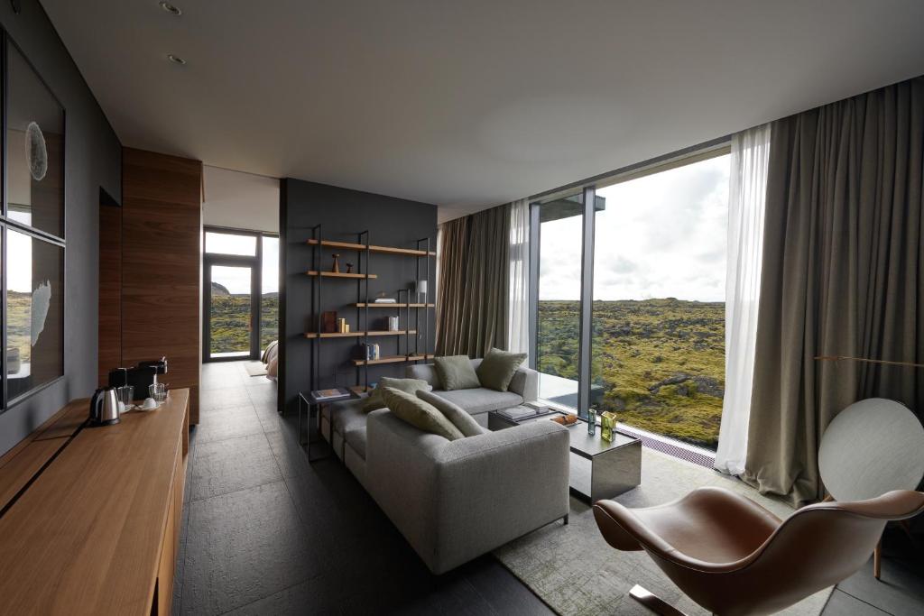 a living room with a couch and a large window at The Retreat at Blue Lagoon Iceland in Grindavík