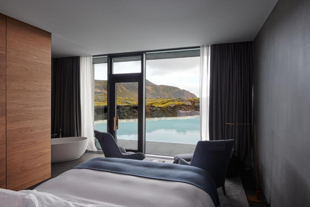 a hotel room with a bed and a tub and a window at The Retreat at Blue Lagoon Iceland in Grindavík