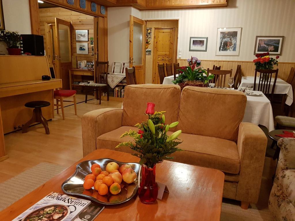 a living room with two couches and a table with fruit at Hotelli Möhkön Rajakartano - Ilomantsi in Petkeljärvi