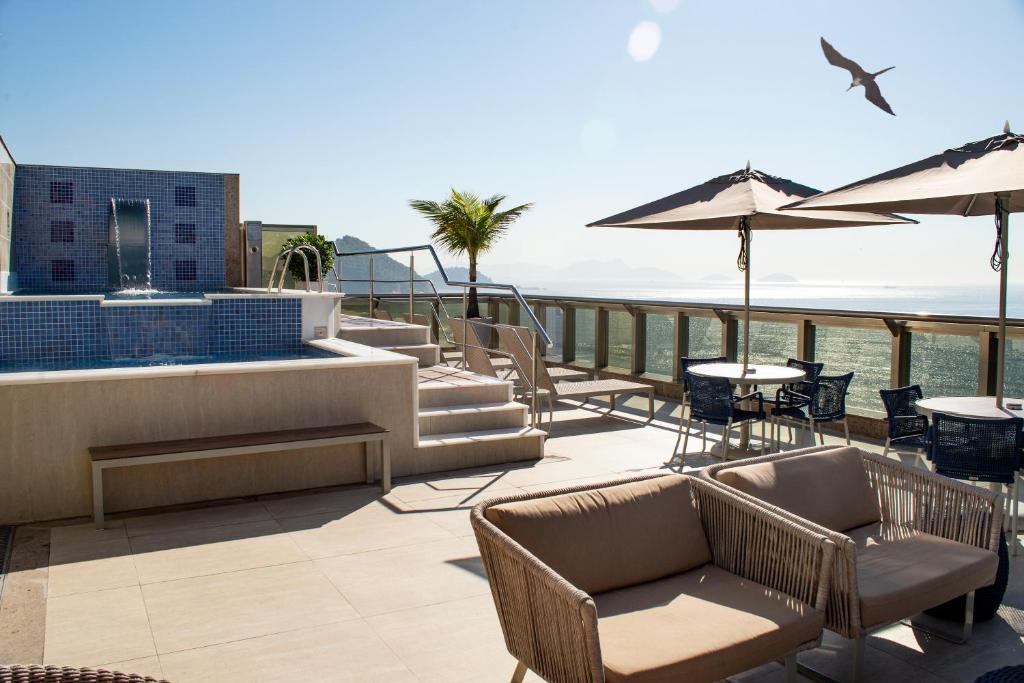 a patio with chairs and tables on a roof at Hotel Astoria Palace in Rio de Janeiro