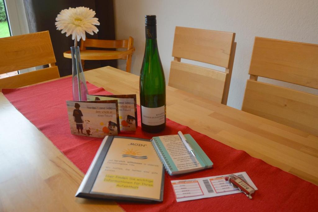 eine Flasche Wein und ein Buch auf dem Tisch in der Unterkunft Bungalow Tilla in Norddeich