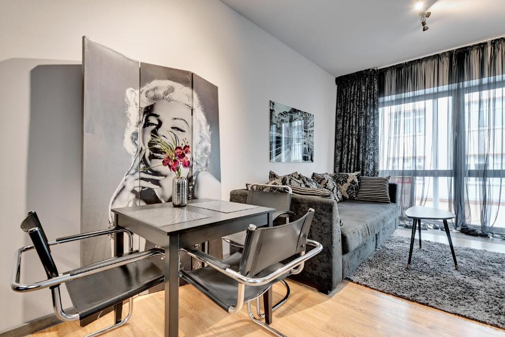 uma sala de estar com uma mesa e um sofá em Dom & House - Apartments Baltiq Plaza em Gdynia