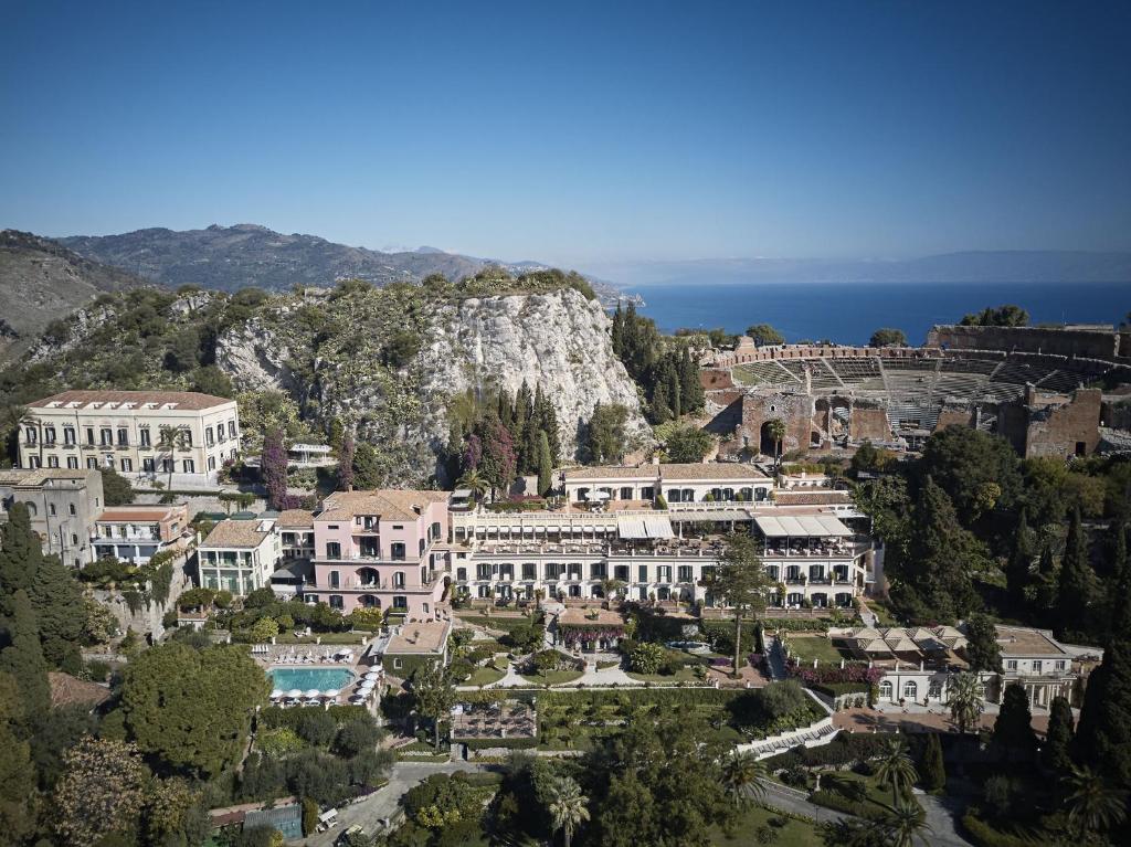 a large building with a view of the ocean at Grand Hotel Timeo, A Belmond Hotel, Taormina in Taormina