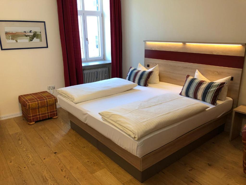 ein Schlafzimmer mit einem großen Bett mit zwei Kissen in der Unterkunft Hotel-Gasthof Flötzinger Bräu in Rosenheim