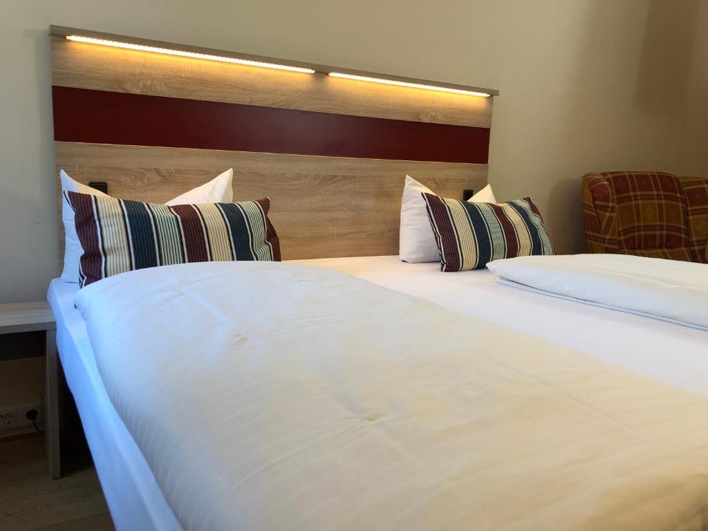 2 camas en una habitación de hotel con cabecero en Hotel-Gasthof Flötzinger Bräu, en Rosenheim